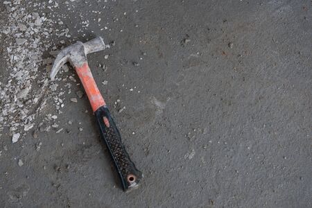 Old hammer, building materials, placed on the cement floor in construction siteの写真素材