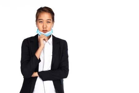 Asian businesswoman take off surgical face mask in black suit jacket, looking at camera, studio lighting isolated on white background, coronavirus, COVID19 conceptの写真素材