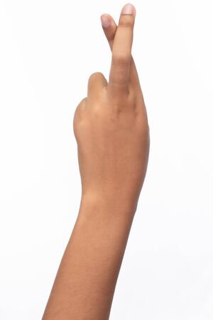 A hand of woman crossed finger, a gesture commonly used to wish for luck, isolated on white backgroundの写真素材