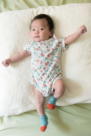 Top view of a cute Asian baby girl wrapped up in bed