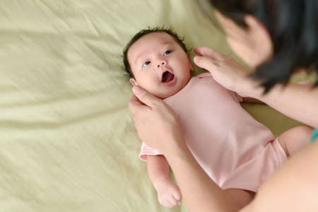 Top view of a cute Asian baby girl wrapped up in bedの写真素材