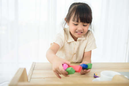 Happy Asian cute child preschooler girl playing toys at homeの写真素材