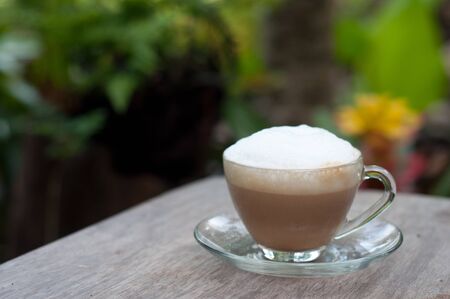 hot capuccino coffee on wood table