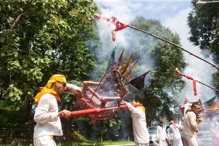 Trang, Thailand - October 15, 2018: Chinese god Monkey King statue on chair carry by people during vegetable festival in Trang, Thailand.のeditorial素材