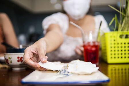 young women preparing vegetable clear shrimp and pork dumplings in quarantine for coronavirus wearing protective mask during covid-19 pandemicの写真素材
