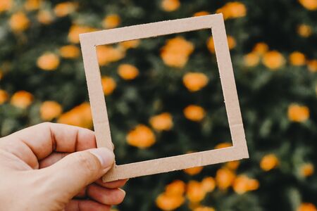 Hand holding blank paper frame with nature bokeh background. Text concept.の写真素材