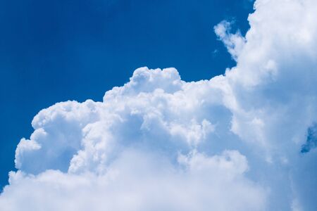 A vertical shot of blue sky and puffy white clouds.の写真素材