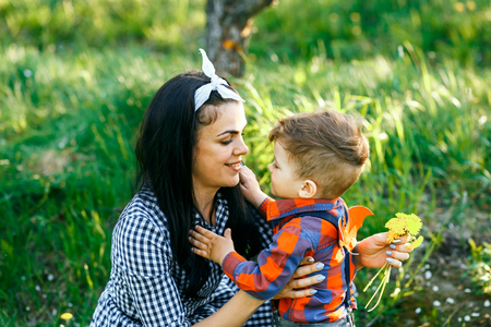 Mother and her son having fun outside in summer hugging and laughing.の写真素材