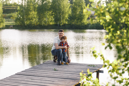 Father and his son having fun outside in summer hugging and laughing.の写真素材