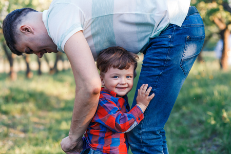 Father and his son having fun outside in summer hugging and laughing.の写真素材