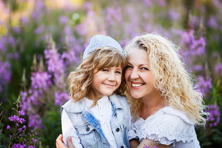 mother and a cute little son hugging and having fun in the fild with flowers in summer. Family and happiness conseptの写真素材