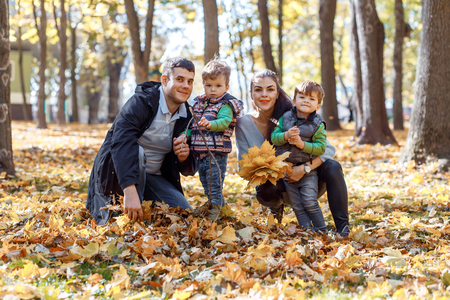Natural pictures of a happy family of four having fun outsiade on a sunny autumn day. Togetherness and happiness conceptの写真素材