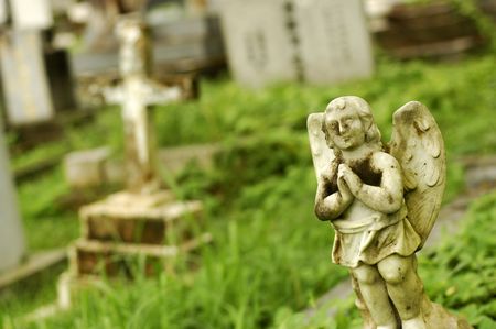 A very old little angel statue at cemeteryの写真素材