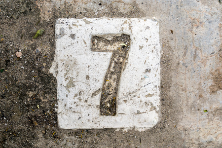 the digits with concrete on the sidewalk 7