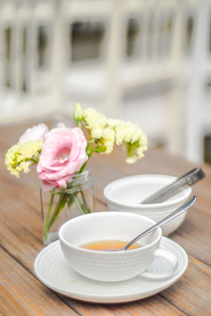 the times on rustic outdoor wood tea table with flowerの写真素材
