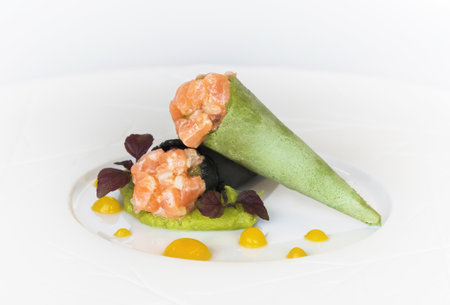 Green cornet and black cornet with salmon and guacamole sauce on a white background in the restaurant. Gourmet cuisineの写真素材