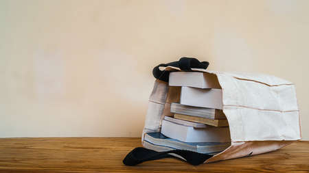 books inside cloth bag on wood table