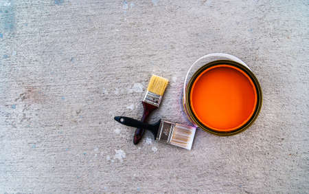 paint brush with open color can on cement floorの写真素材