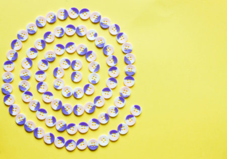 Spiral pattern of buttons on yellow backgroundの写真素材