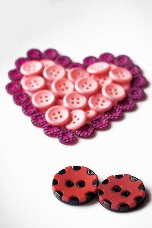 Two buttons look like a couple and a buttons which is in shape of heartの写真素材