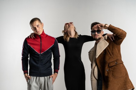 Two guys and girl in stylish casual bright and dark colorful clothes