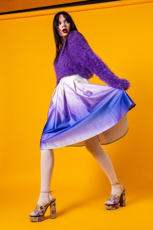 Fashion model girl full length portrait isolated on orange backgroundの写真素材