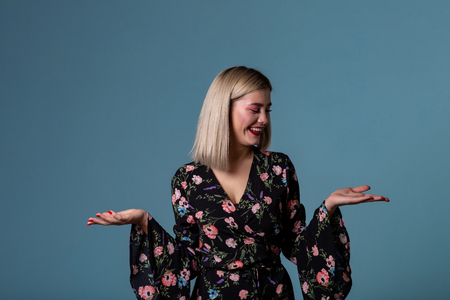 Lovely smiling blonde girl holding something imaginaryの写真素材