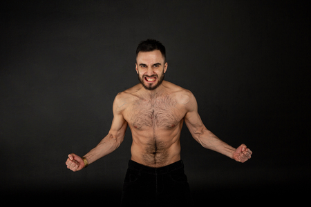 Studio shot of young shirtless man with beardの写真素材