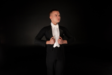 Serious handsome young dancer in black suitの写真素材