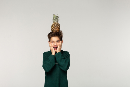 Amazed horrified male teenager keeps mouth opened, hands on cheeksの写真素材