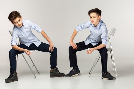 Two boys teenagers in blue shirts and black pantsの写真素材