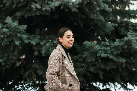 Outdoor portrait of young beautiful girl in cold winter weather in park