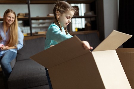 Family unpacking cardboard boxes at new home