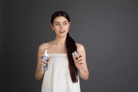 Beautiful young european female with long brunette hair in bath towelの写真素材