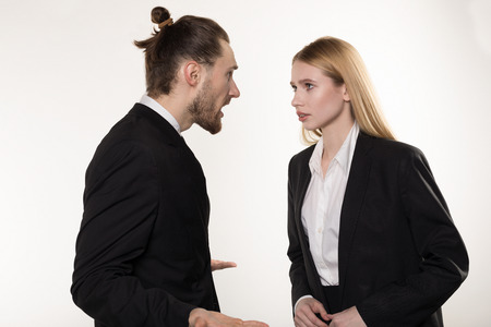 Attractive businessman with beard and trendy hairstyle in black suit screaming at his subordinate who cant cope the taskの写真素材