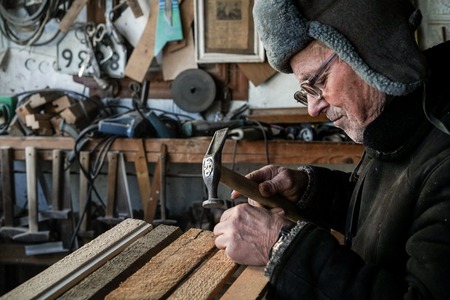 Serious mature old grandfather in grey warm hat, in eyeglassesの写真素材
