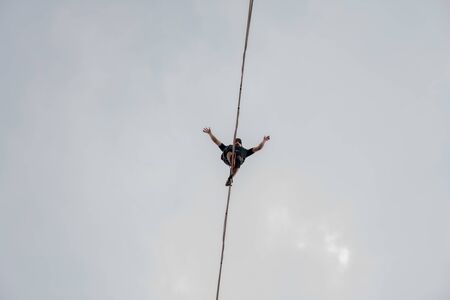 KrakÃ³w, Poland, 05/07/2019 Photo from the bottom, brave tightrope walker with spread arms in the middle of the wayのeditorial素材