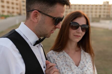Close up portrait of lovely young couple in elegant clothes and sunglassesの写真素材