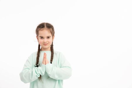 Portrait of angel-like child in white morning light in studio. Little European girl with brunette hair looking attractive and balanced showing neutral emotions and radiating tranquility.の写真素材
