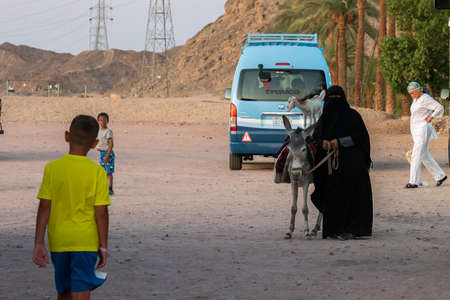 Luxor, Egypt - 29.03.2020: People walking and group of woman carrying hay in the street. Travel and vacation conceptのeditorial素材