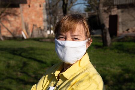 Woman wearing a face mask, looking at camera, close upの写真素材