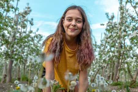 Close up of a casual student girl with brunette girl who enjoying spring day in the blooming garden