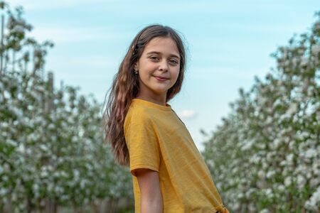 Beautiful brunette curly girl in yellow t-shirt looking at the camera