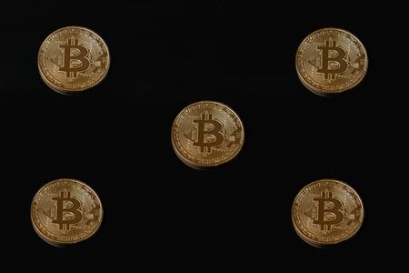 Composition of five golden bitcoin coins isolated on black backgroundの写真素材