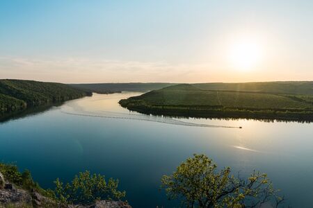 Panorama of a winding river with a floats motor boat