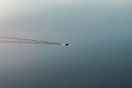 Stunning image of a boat, motor yacht racing through the river in sunlightの写真素材