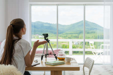Woman blogger talking with followers, live streaming, looking to web cam. Making video call to friends and parents. Social media, stay home and quarantineの写真素材