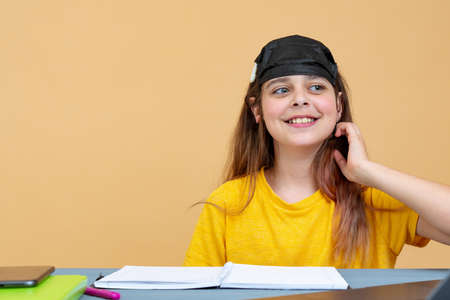 Girl in a black mask on her head works on a laptop at home in isolation. Work on remote access. Self isolationの写真素材