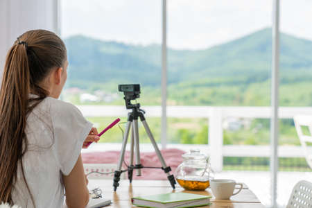 Woman blogger talking with followers, live streaming, looking to the camera. Making video call to friends and parentsの写真素材