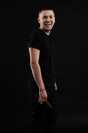 Barber Shop Concept. Smiling Handsome Young Brunete In black T Shirt Is Standing On The Pureの写真素材
